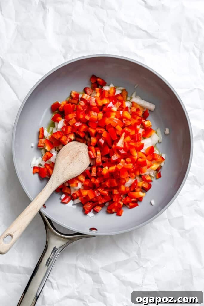 Effortless Vegetarian Enchiladas 9 Chopped bell peppers and onions sautéing in a skillet for enchilada filling.