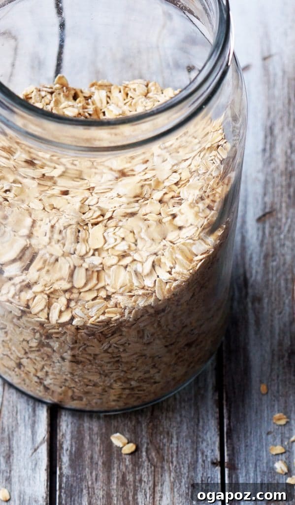 Perfectly Chewy Oatmeal and Peanut Butter Cookies 4 Oatmeal in a glass jar with a wooden spoon.