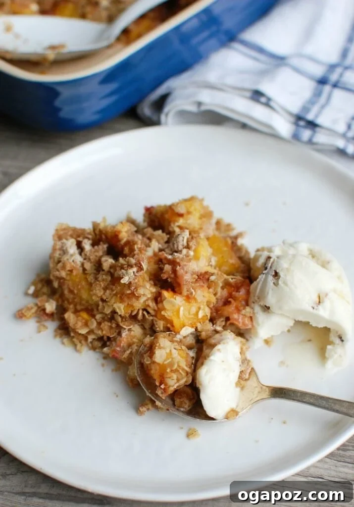 Golden Baked Peach Crumble 3 A close-up of the crumbly oat topping on a freshly baked peach crisp, with warm peaches visible underneath.