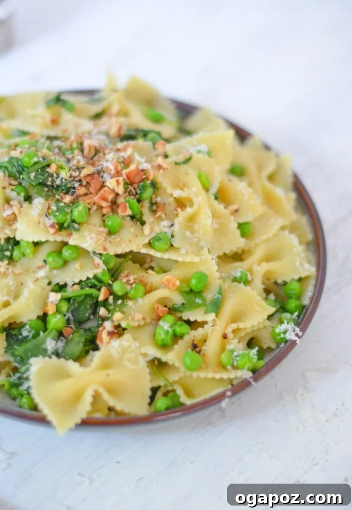 Wholesome Meals in Minutes 29 Pea Pasta with spinach, served in a white bowl with a fork.