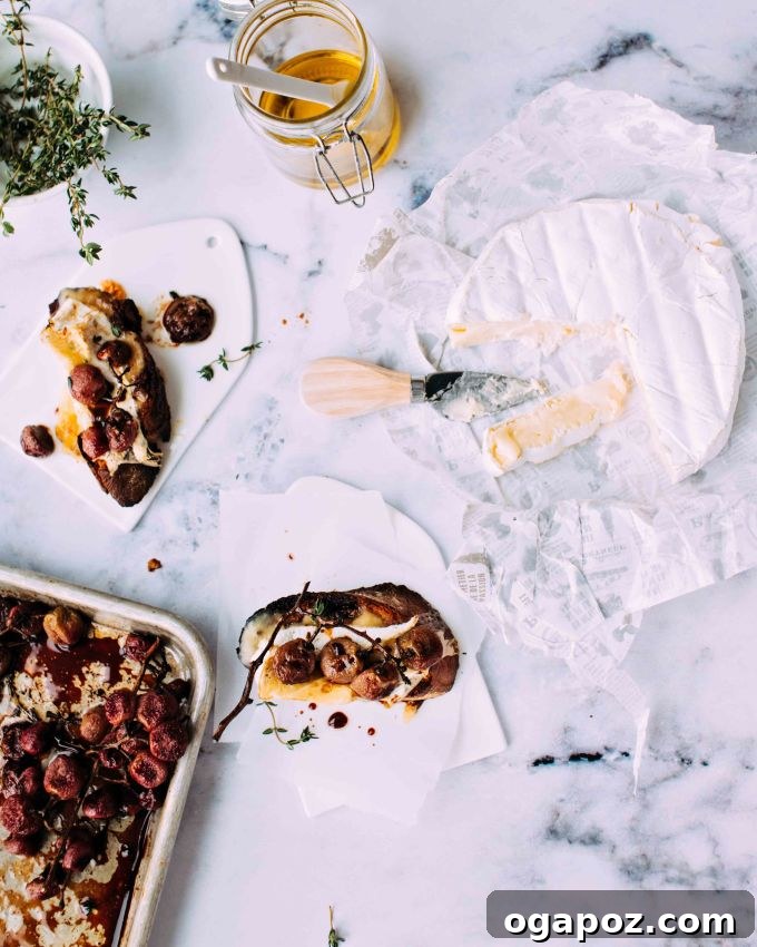 Caramelized Grape Camembert Crostini 3 Camembert crostini with roasted grapes on a countertop with a wheel of camembert.