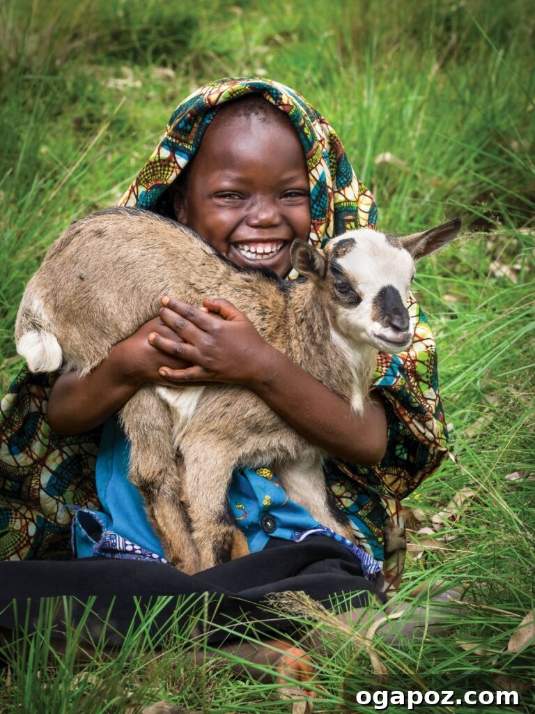 Give Back, Win Big: Our Holiday Season Giveaway 2 A young girl, Chanian Niyonyishu, 5, from Gasorwe, Burundi, smiles with a baby goat. Her mother, Zuena Mukeshimana, notes that the goat will fertilize their land for better food production, symbolizing hope and sustainability through World Vision's Gift Catalog.