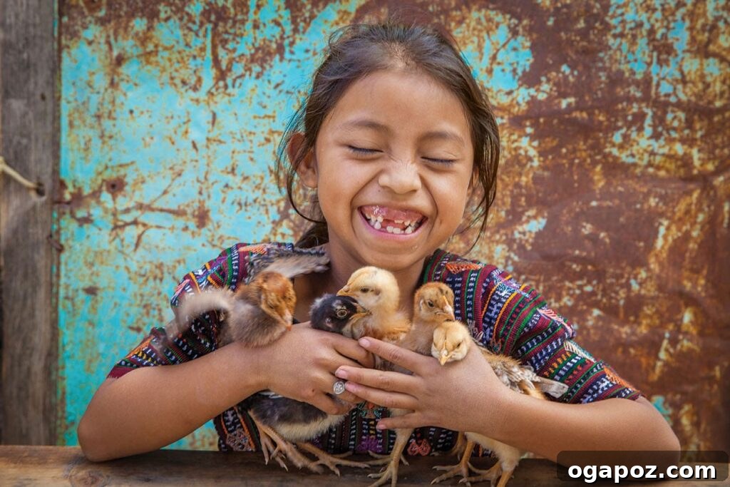 Give Back, Win Big: Our Holiday Season Giveaway 5 Yennifer proudly holds baby chicks received by her family through the World Vision Gift Catalog program, symbolizing new beginnings and sustainable livelihoods.