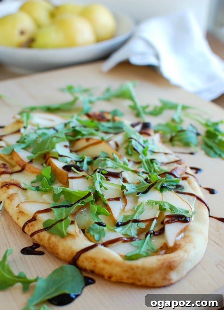 Gourmet Pear and Brie Flatbread 6 Detail shot of a Pear and Brie Flatbread, garnished with fresh arugula.