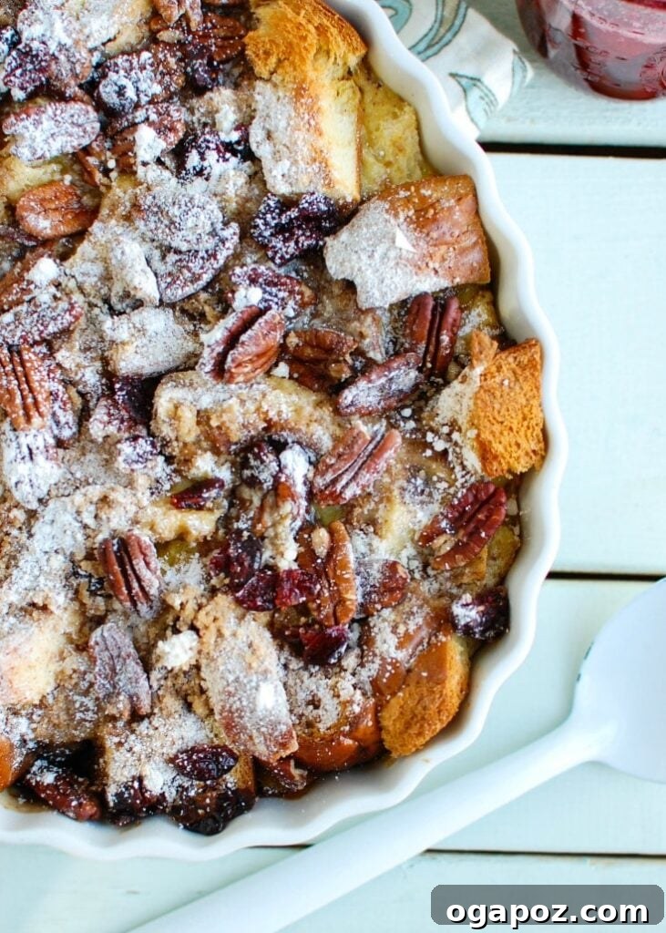 Make Ahead Eggnog French Toast Bake with Festive Cranberry Maple 5 Overnight Eggnog French Toast Bake with Cranberry Maple Syrup in white pan, ready to be served.