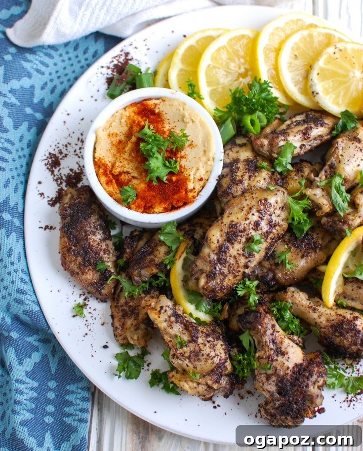 Zesty Sumac Lemon Wings 2 Perfectly baked Sumac Lemon Chicken Wings, golden and crispy, garnished with fresh herbs and lemon slices.