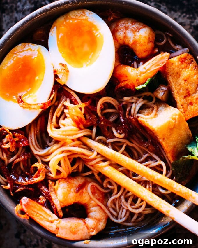 Close-up of Coconut Shrimp Laksa, highlighting the shrimp and rich curry broth.