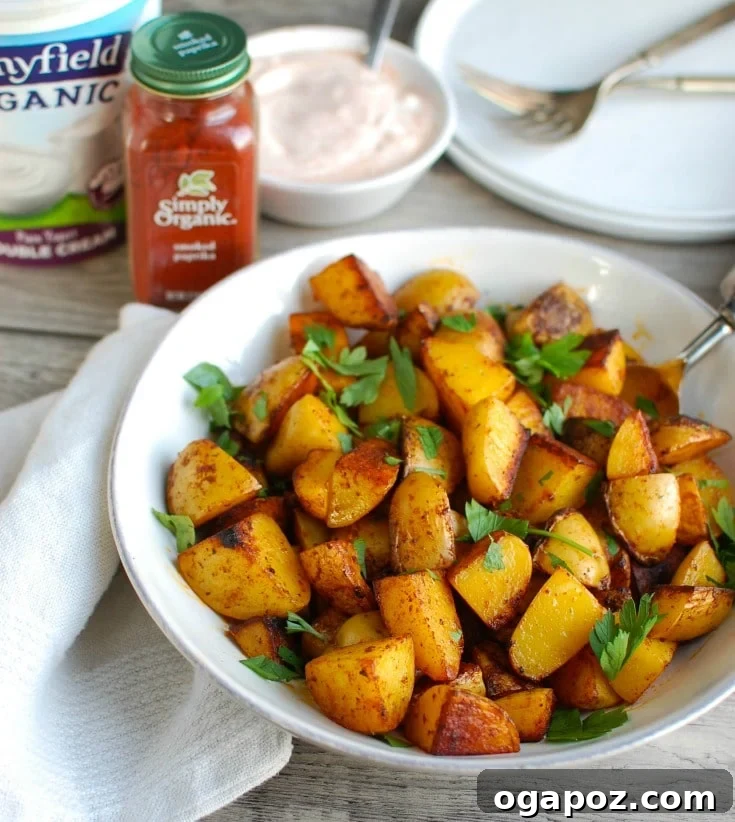 Smoky Paprika Potatoes with Cooling Spiced Yogurt 3 Close-up shot of Paprika Roasted Potatoes garnished with fresh parsley, showing the crispy texture and the rich reddish hue from the smoked paprika.