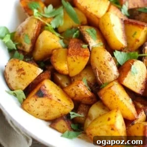A top-down view of Paprika Roasted Potatoes with Spiced Yogurt Sauce, styled for a recipe card, showing the golden potatoes and creamy dip.