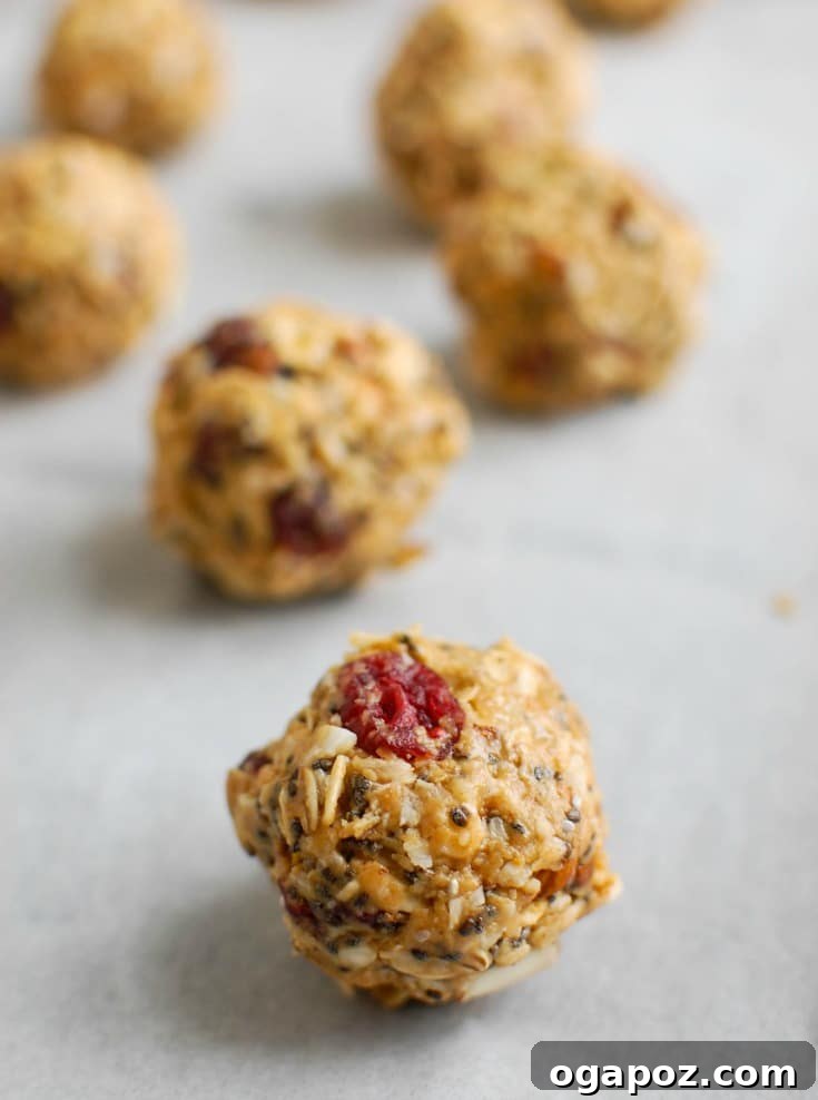 Almond Cranberry Energy Balls 4 A close-up of a hand mixing the ingredients for Cranberry Almond Energy Bites in a bowl, showcasing the rich textures.