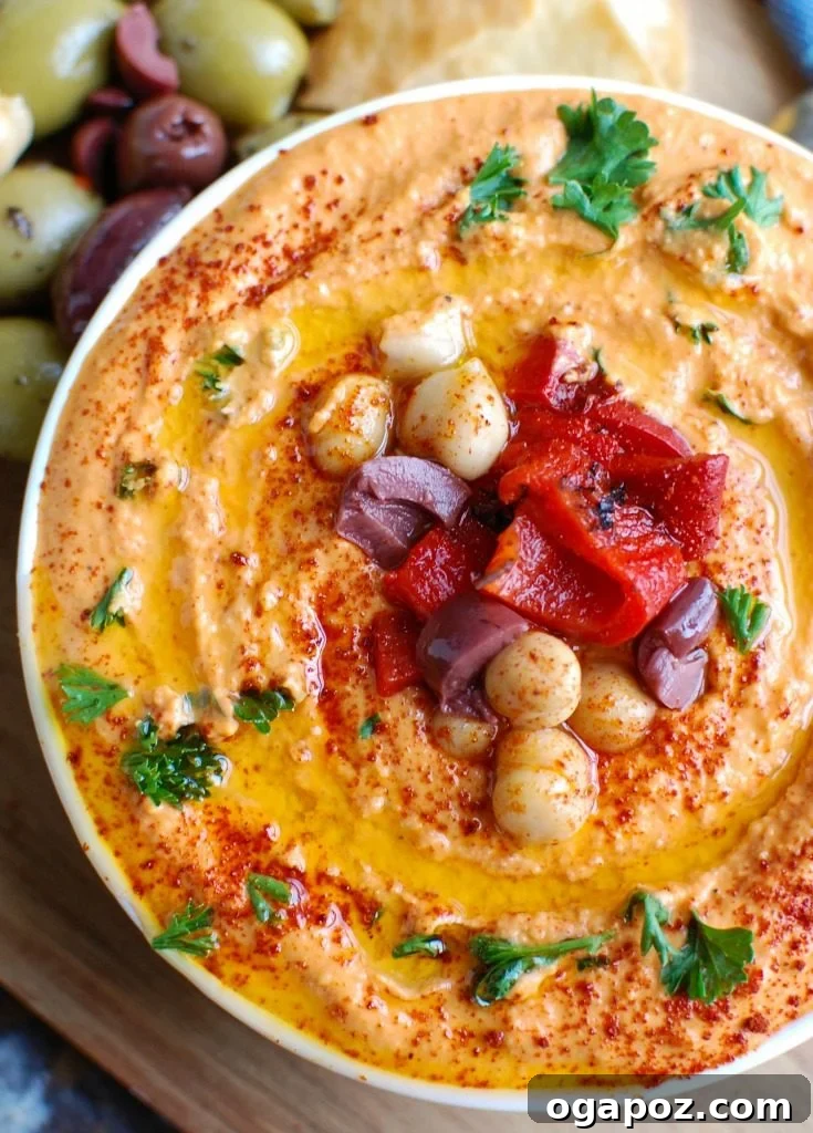 Creamy Roasted Red Pepper Greek Yogurt Hummus 3 Close-up shot of the creamy texture of Roasted Red Pepper Greek Yogurt Hummus, highlighting the specks of red pepper and smooth consistency.