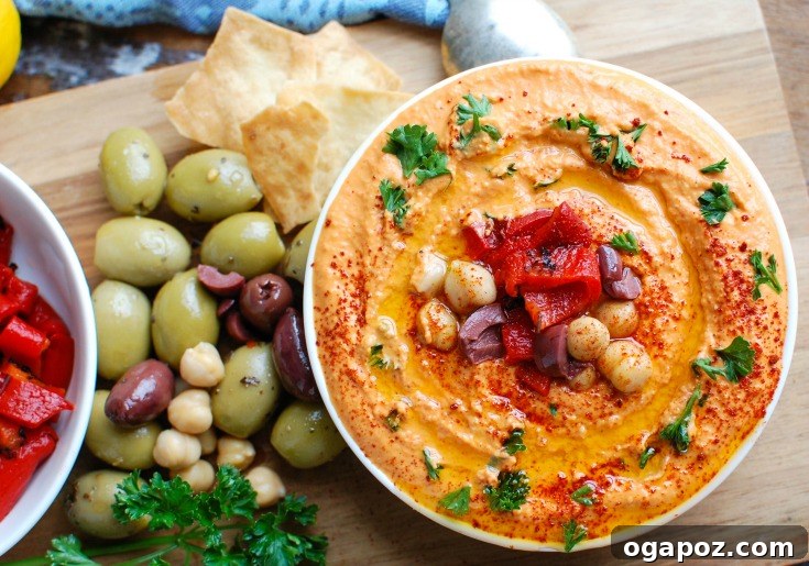 Creamy Roasted Red Pepper Greek Yogurt Hummus 5 A bowl of Roasted Red Pepper Greek Yogurt Hummus garnished with fresh parsley and a swirl of olive oil.