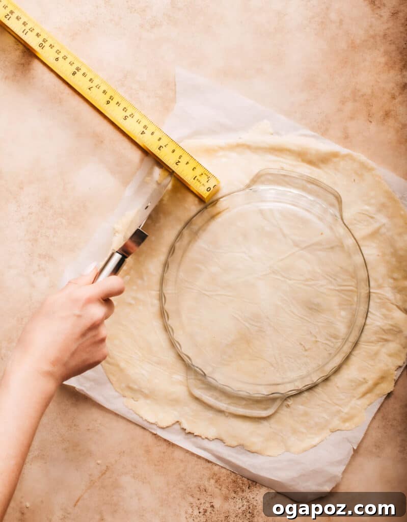 Foolproof Pie Crust You Can Make By Hand 17 Measuring a rolled-out pie crust to ensure correct size for the pie dish.