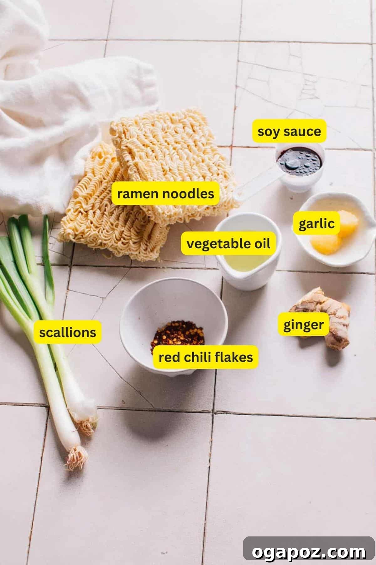 Fiery Chili Ramen 3 A selection of fresh ingredients laid out on a kitchen counter for making Chili Oil Ramen, including instant ramen noodles, bright green scallions, potent red chili flakes, aromatic fresh ginger, a bottle of vegetable oil, pungent garlic, and a bottle of savory soy sauce, all ready to be transformed into a delicious meal.