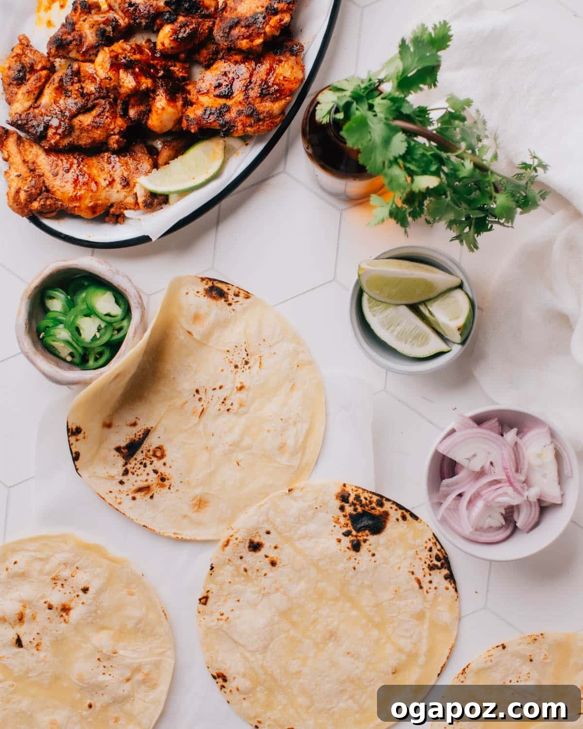 Authentic Chicken Street Tacos 3 Ingredients for assembling chicken street tacos, including tortillas, grilled chicken, jalapeño slices, sliced onions, cilantro, and other toppings.
