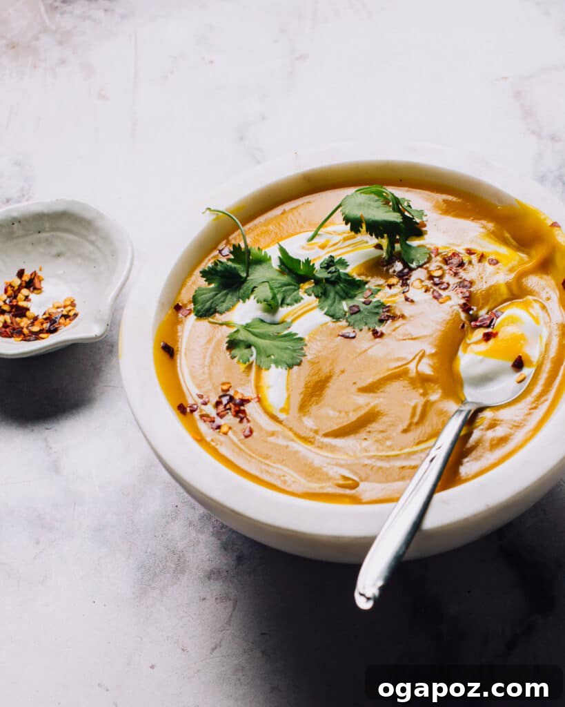 Golden Spiced Sweet Potato and Chickpea Soup 2 A vibrant bowl of Sweet Potato Coconut Milk Soup, garnished with fresh cilantro, ready to be enjoyed.