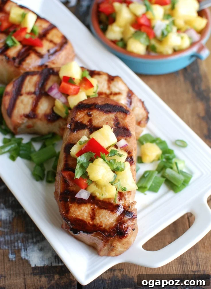 Sweet and Tangy Island Pork Chops 2 Platter of perfectly grilled Hawaiian pork chops topped with fresh pineapple salsa, ready to be served for a summer meal.