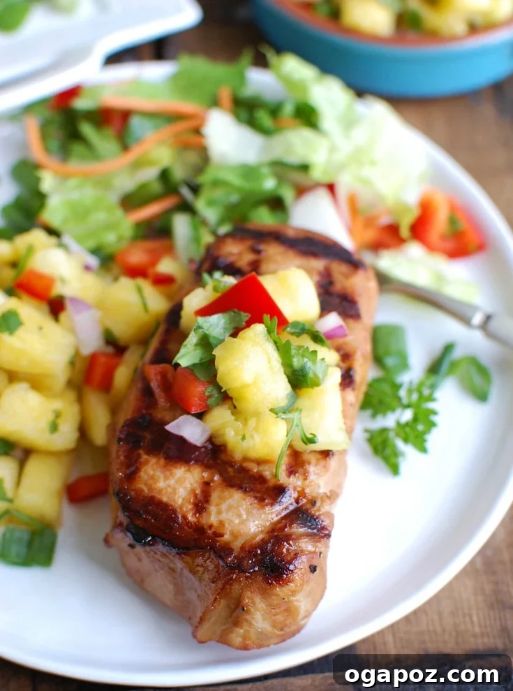 Sweet and Tangy Island Pork Chops 3 Close-up of a perfectly grilled Hawaiian pork chop with a fork, showcasing its juicy interior and flavorful crust, ready to be enjoyed.