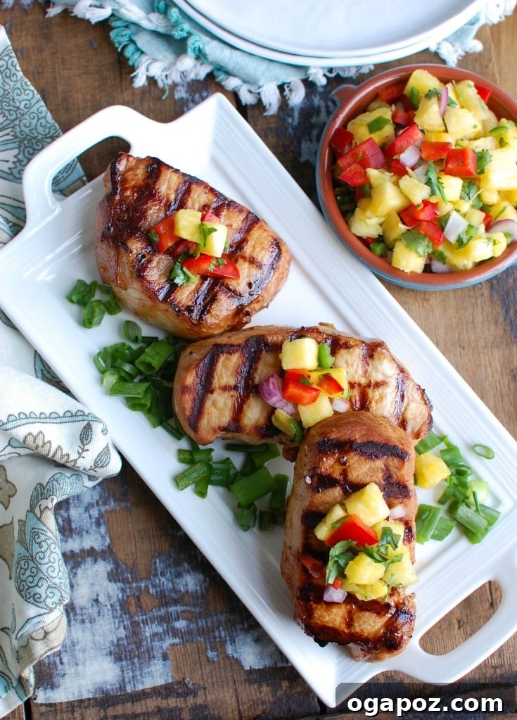 Sweet and Tangy Island Pork Chops 6 Beautifully plated Grilled Hawaiian pork chop with salsa, garnished on a white plate with a napkin, ready for a delicious meal.