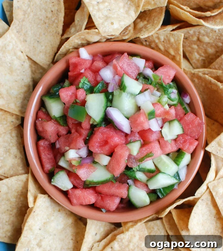 Refreshing Cucumber Pico 4 Hands gently mixing diced watermelon, cucumber, finely chopped red onion, and fresh cilantro in a clear glass bowl, showcasing the colorful ingredients.