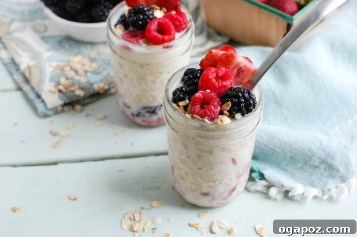 Triple Berry Bliss Overnight Oats 4 Two mason jars filled with Overnight Triple Berry Oatmeal, one open showing the creamy layers of oats, milk, yogurt, and mixed berries, and another sealed, ready for refrigeration. This image highlights the convenience and ease of meal prepping this healthy breakfast.