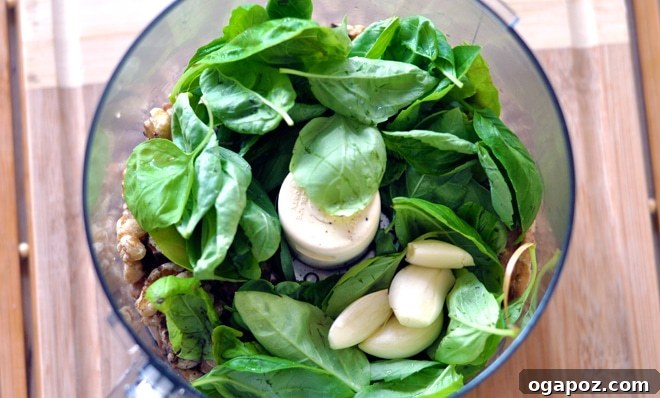 Garden Fresh Basil Pesto 4 Close-up of fresh basil leaves, peeled garlic cloves, and walnuts, ready for pesto making.