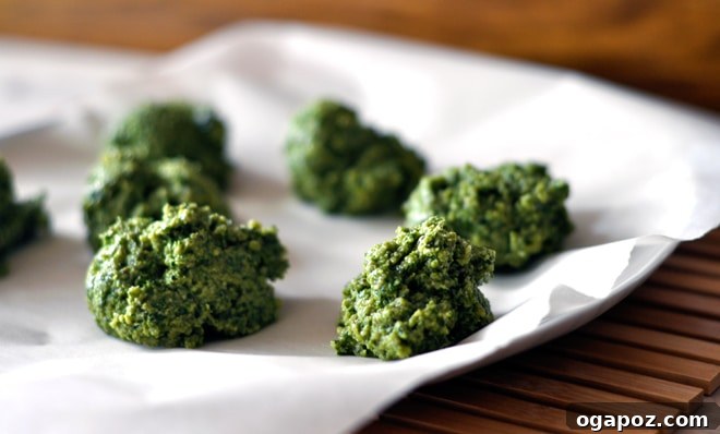Garden Fresh Basil Pesto 6 Frozen dollops of basil pesto on parchment paper, ready to be transferred to a freezer bag.