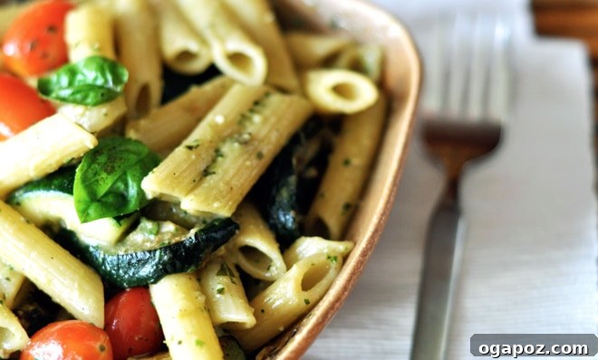 Garden Fresh Basil Pesto 7 A bowl of freshly made basil pesto, garnished with a basil leaf and pine nuts.