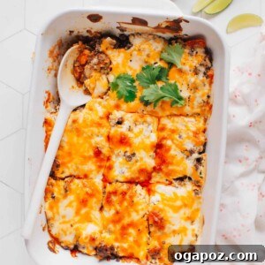 A top-down view of a delicious Walking Taco Casserole, showing the melted cheese, seasoned meat, and crunchy chip edges, ready for serving.
