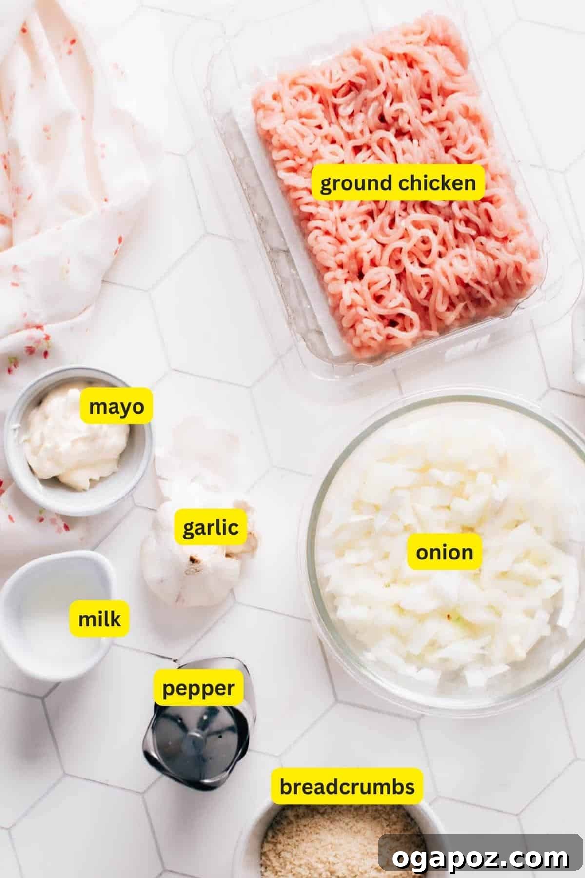 Irresistibly Juicy Ground Chicken Burgers 3 A top-down view of all ingredients neatly arranged for making ground chicken burgers, including ground chicken, breadcrumbs, fresh garlic, mayonnaise, minced onion, a bowl of spices, and a small jug of milk.