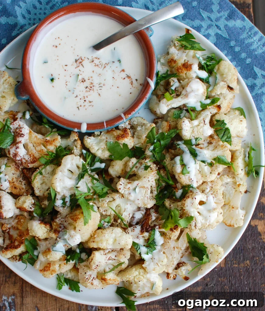 Za'atar Roasted Cauliflower with Creamy Tahini-Yogurt 3 Close-up of golden brown Za'atar Roasted Cauliflower florets on a baking sheet, ready to be served.