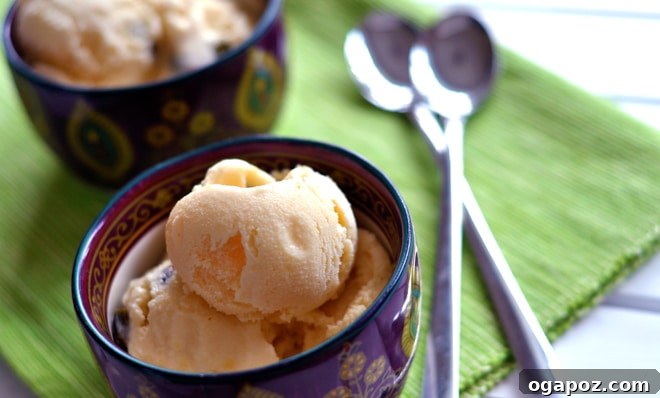 A bowl filled with fresh mango chunks, alongside measuring cups of milk, cream, and sugar, symbolizing the simple ingredients for kulfi.