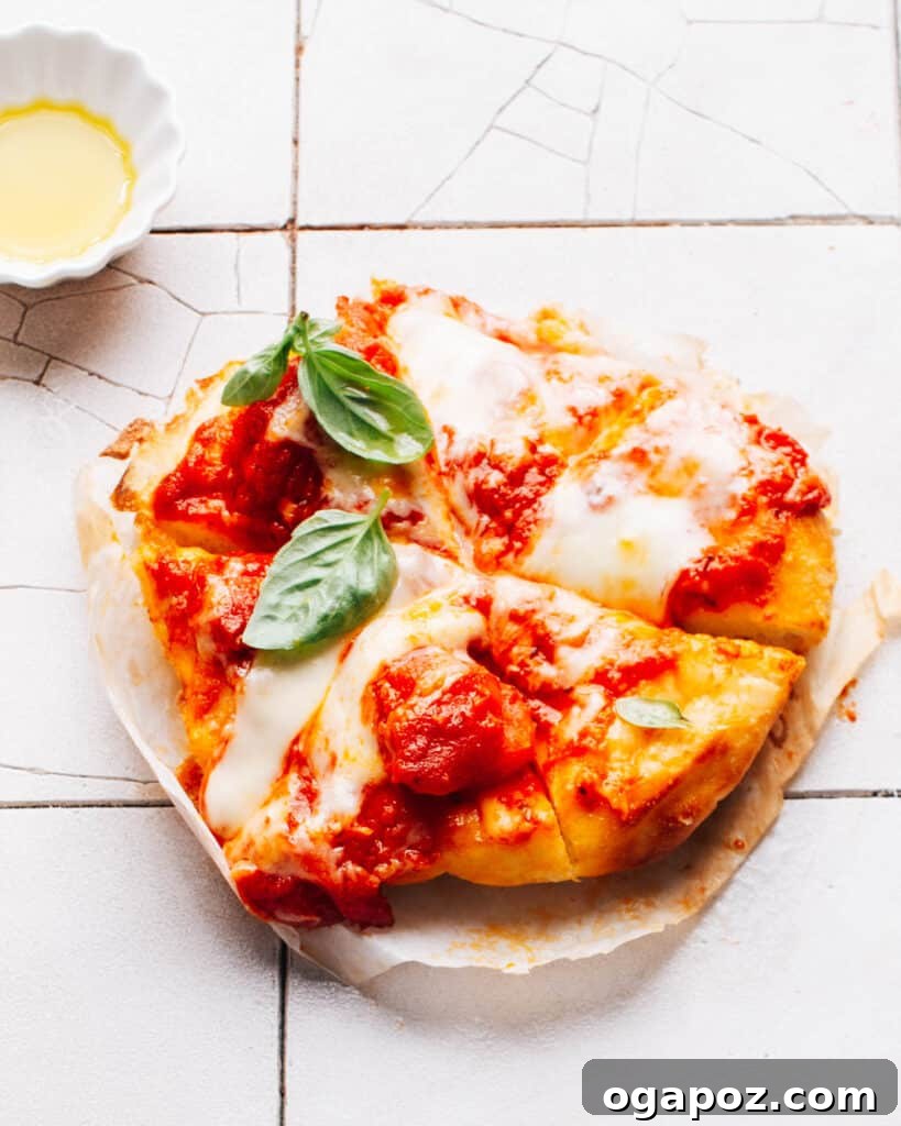 The Best Homemade Pizza Sauce You'll Ever Make 3 Crispy air fryer pizza with melted cheese and fresh basil on a counter.