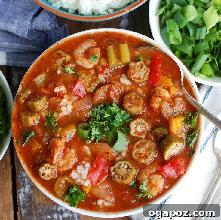 Slow-Cooked Cajun Jambalaya Soup 3 Close-up shot of rich Crock-Pot® Jambalaya Soup, showcasing chicken, andouille sausage, shrimp, and vegetables in a savory tomato broth.