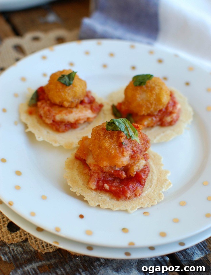 Crispy Shrimp Caprese Bites 3 Close-up of baked Tomato Basil Mozzarella Popcorn Shrimp Bites in a skillet, showcasing melted mozzarella, fresh basil, and crispy shrimp, ready to be served at a holiday party.