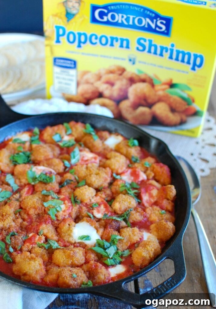Crispy Shrimp Caprese Bites 4 A serving platter of Tomato Basil Mozzarella Popcorn Shrimp Bites, garnished with fresh basil leaves, ready for guests at a holiday party.