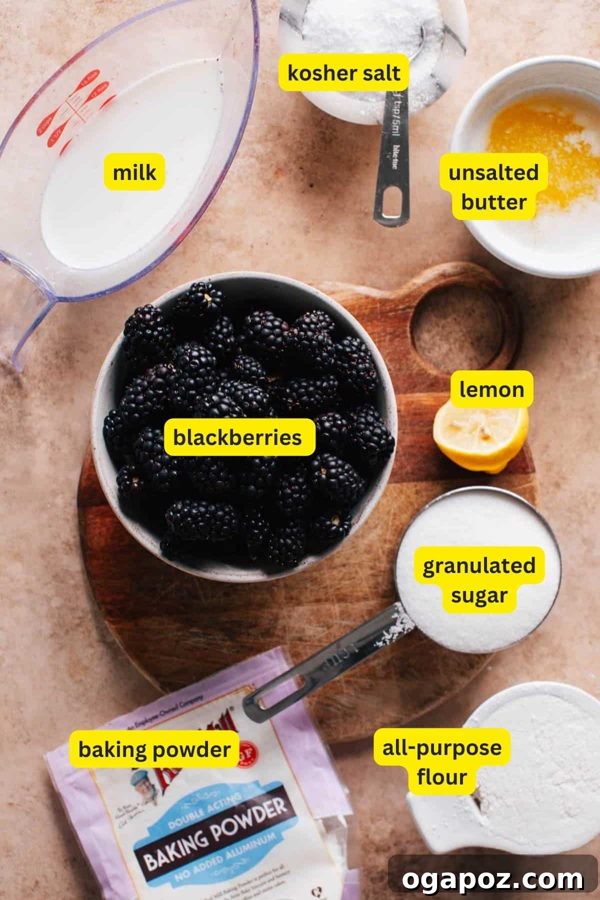 Homestyle Blackberry Cobbler 3 Ingredients for Blackberry Cobbler arranged on a kitchen countertop include blackberries, lemon, milk, granulated sugar, all-purpose flour, baking powder, kosher salt, and unsalted butter