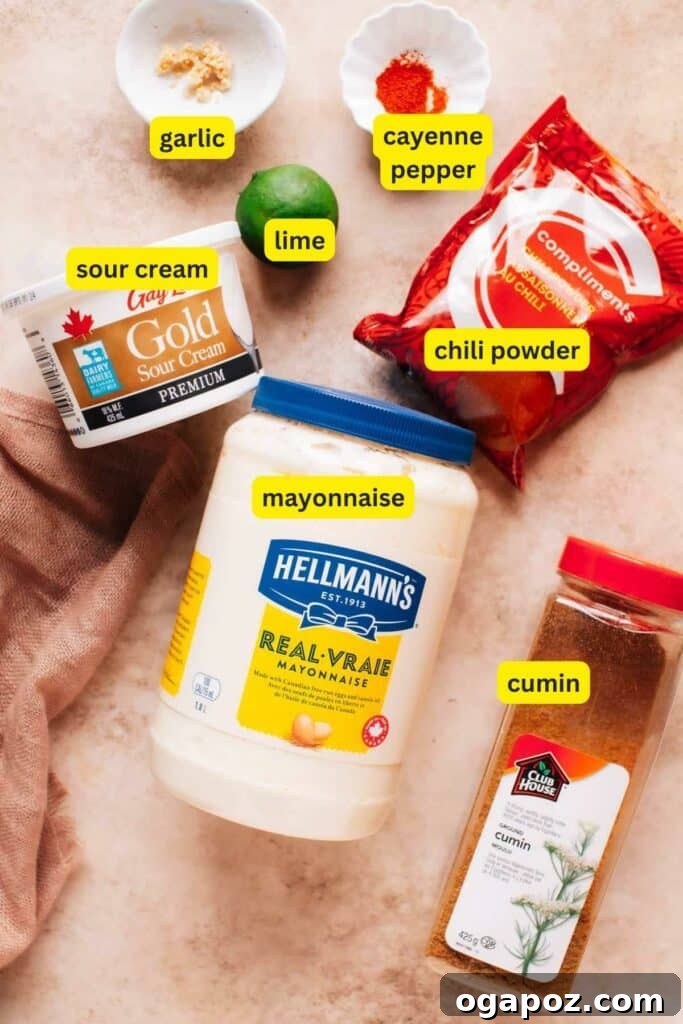 Delicious Creamy Baja Fish Taco Sauce 4 Ingredients for Baja sauce are laid out on the kitchen countertop, including mayonnaise, garlic, sour cream, lime, chili powder, cumin, and cayenne pepper.