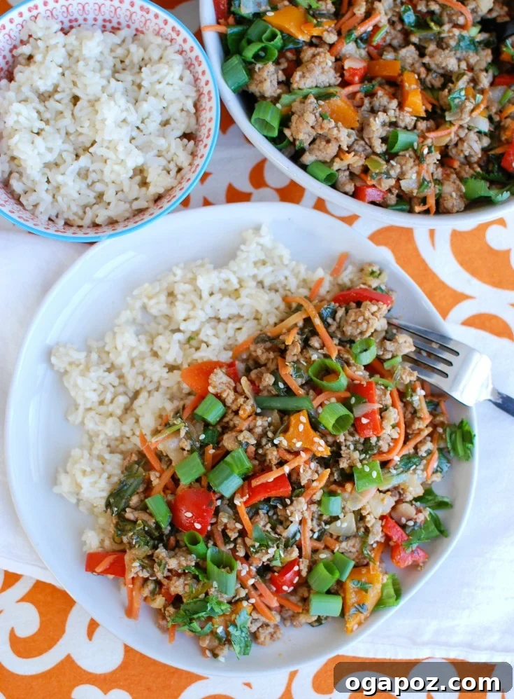 Close-up of fresh ingredients for Easy Thai Pork Stir-Fry including ground pork, bell peppers, carrots, bok choy, garlic, and lime.