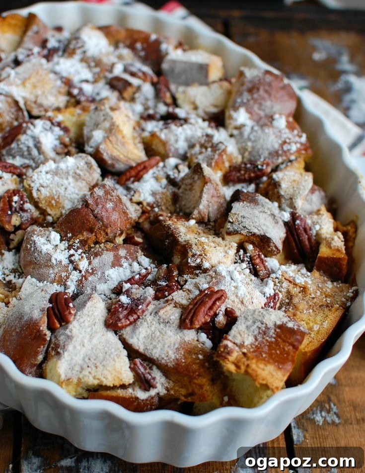 Cozy Overnight Gingerbread French Toast Bake 2 Golden brown Overnight Gingerbread French Toast Casserole garnished with powdered sugar.
