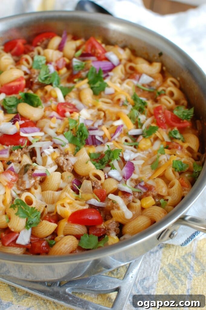 Easy One-Pan Taco Beef Pasta 3 One Skillet Beef Taco Pasta cooking in a cast iron skillet