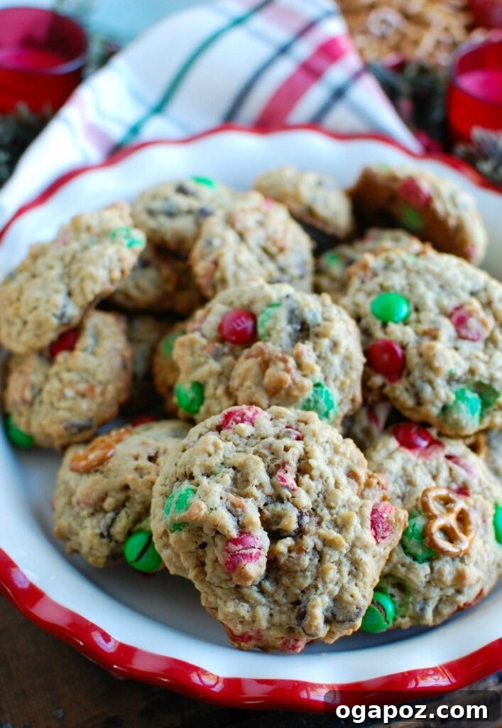 Peanut Butter Pretzel Chocolate Chunk Cookies 2 Close-up of freshly baked Peanut Butter Pretzel Chocolate Chip Cookies loaded with pretzels, M&Ms, and chocolate chips on a cooling rack.
