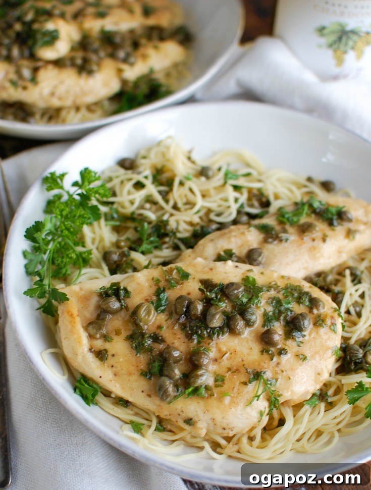 Zesty Lemon Caper Chicken 2 Golden brown Chicken Piccata served in a white bowl, garnished with fresh parsley.