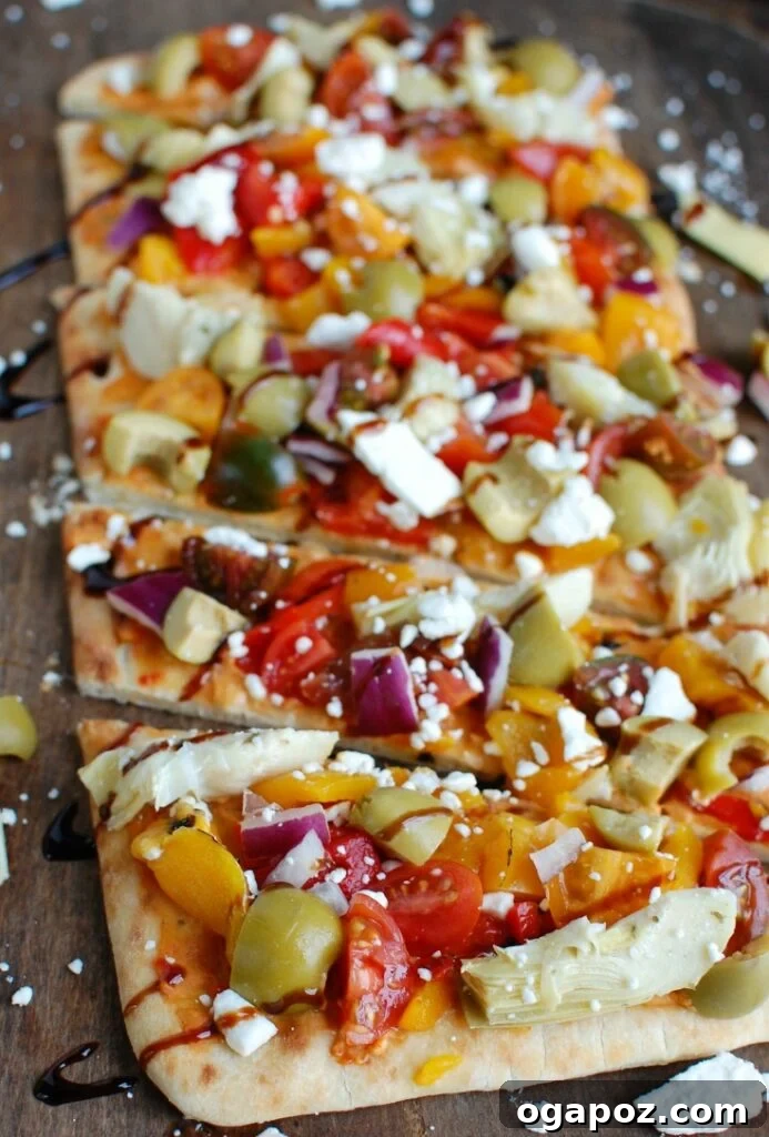 Sun-Drenched Mediterranean Flatbread 2 Vibrant Mediterranean Flatbread topped with hummus, olives, feta, and fresh vegetables, served on a rustic wooden board.
