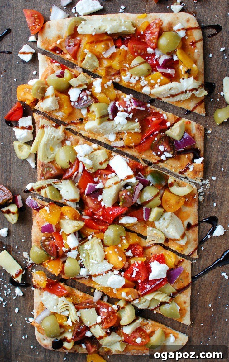 Sun-Drenched Mediterranean Flatbread 6 Top-down view of a fully loaded Mediterranean Flatbread, ready to be served.