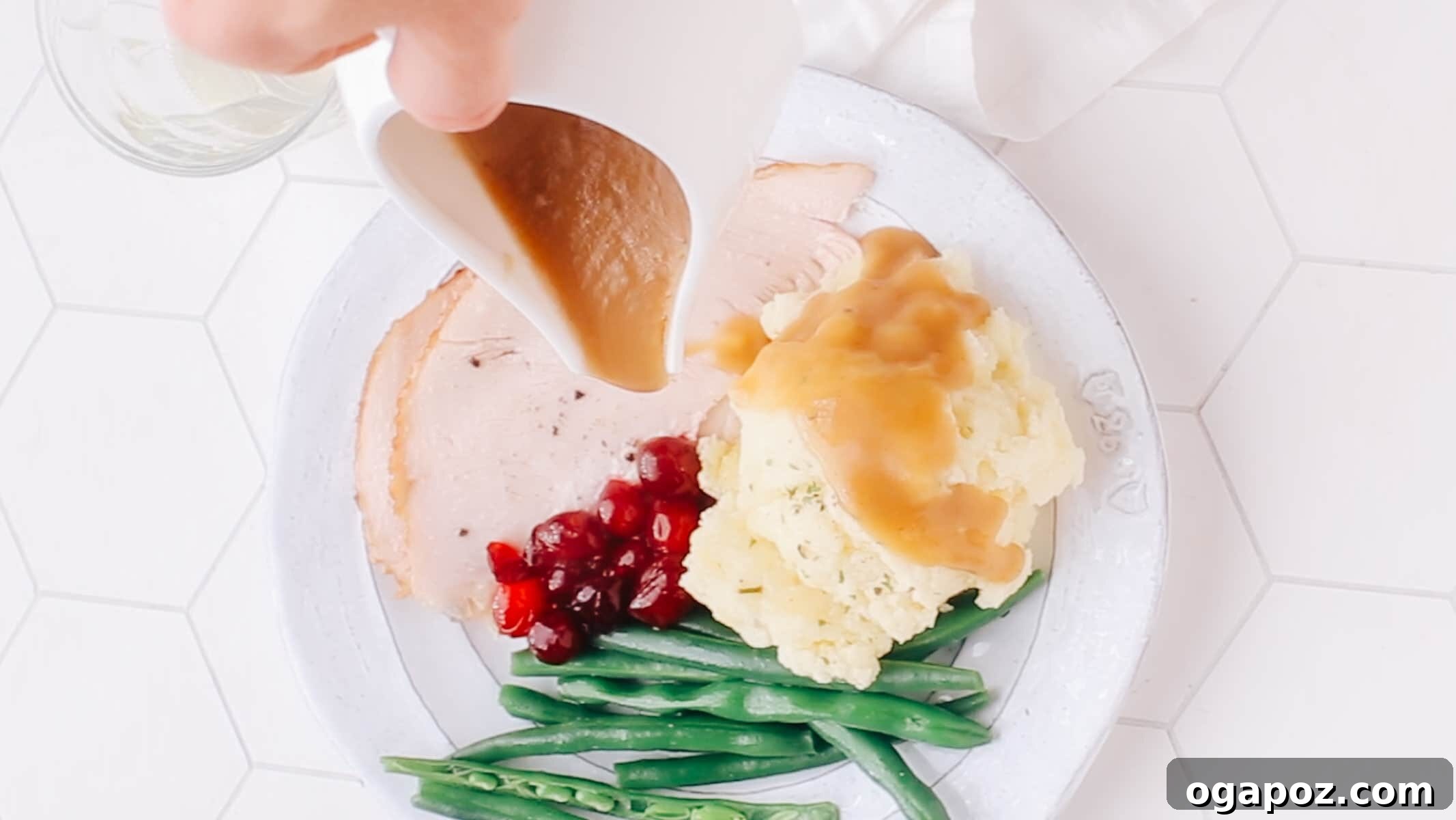 The Mashed Potato Recipe That Changes Everything 10 A Thanksgiving dinner spread featuring a large bowl of mashed potatoes being served with gravy over a turkey.