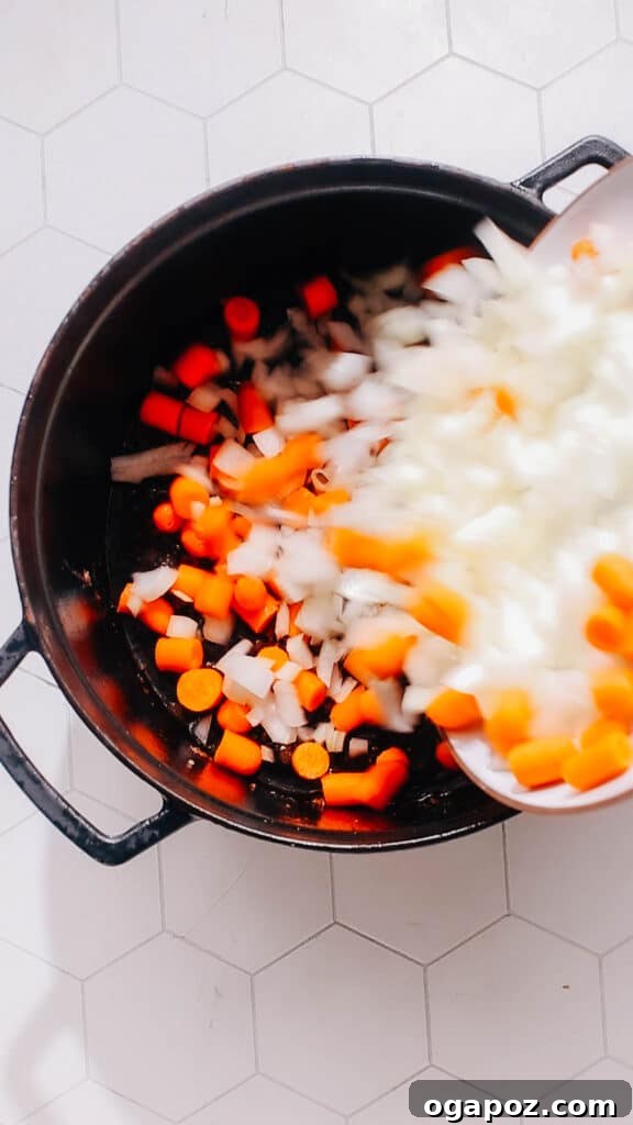 Rustic Beef Pot Pie 5 Step 2: Sautéing chopped onions and carrots in the same pot until tender and fragrant.