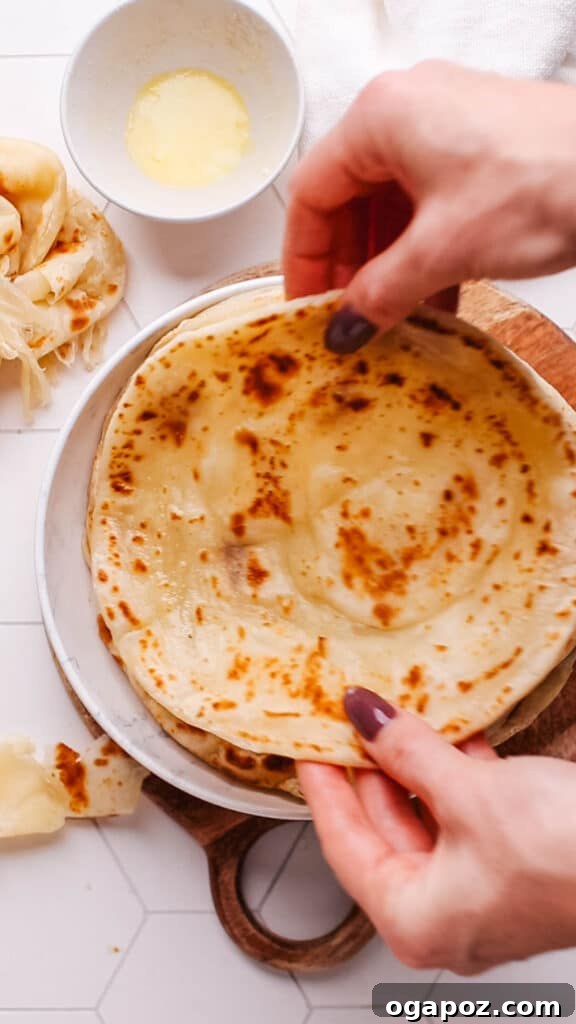 Golden Flaky Paratha Bread 20 Placing paratha on a plate.