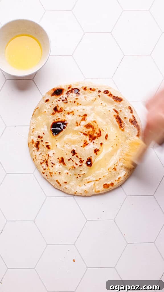 Golden Flaky Paratha Bread 3 Brushing cooked paratha with butter.