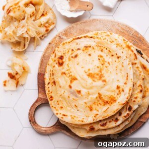 Paratha on a board with some showing their flaky layers